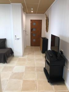 a living room with a television and a tiled floor at Caballito de Mar in Roses