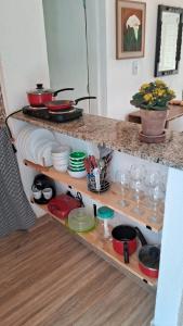 a kitchen with a counter with plates and dishes at Meu Chalé in Miguel Pereira