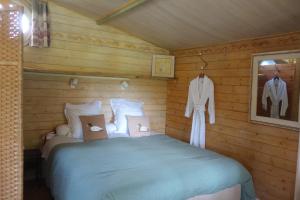 1 dormitorio con 1 cama en una cabaña de madera en Les Iris - Domaine du Lac de la Vallée, en La Roquette-sur-Siagne