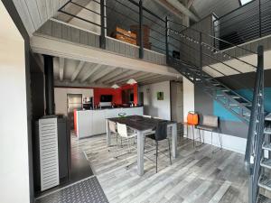 a kitchen and dining room with a table and a staircase at Duplex avec poêle à granulés et garage à motos in Montaigut-le-Blanc