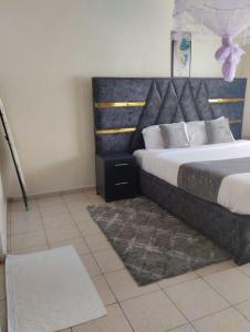 a bedroom with a large bed and a rug at Exquisite 2BR Ensuite Apartment close to Rupa Mall, Mediheal Hospital, and St Lukes Hospital in Eldoret