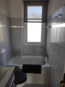 a bathroom with a tub and a toilet and a window at Appartement Vue Mer Menton in Menton