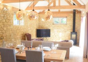 a dining room with a table and a couch at Lily Rose Cottage in Broadway