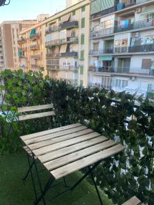 drewniana ławka siedząca przed budynkiem w obiekcie Apartamento de habitaciones privadas en el centro de Málaga w Maladze