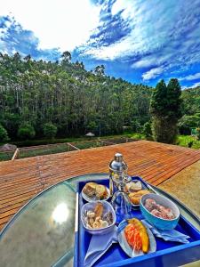 um tabuleiro de comida sentado numa mesa de vidro em Refúgio Santa Helena - Domo Zen em Salesópolis