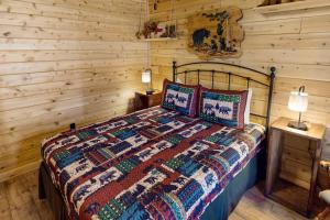 1 dormitorio con 1 cama en una cabaña de madera en Blackbear Log Cabin en Morrisville