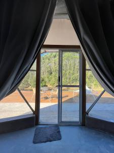 Habitación con una gran puerta de cristal con vistas. en Refúgio Santa Helena - Domo Zen, en Salesópolis