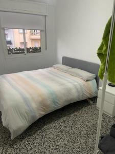 łóżko w sypialni z oknem w obiekcie Apartamento de habitaciones privadas en el centro de Málaga w Maladze