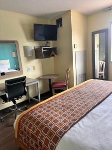ein Hotelzimmer mit einem Bett, einem Schreibtisch und einem Stuhl in der Unterkunft Howard Johnson by Wyndham Clarksville Tennessee in Clarksville