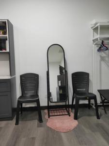 2 sillas negras y un espejo en una habitación en Vista Bangi NAQ Homestay - Studio Near UKM, en Kajang