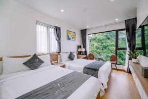a hotel room with two beds and a large window at CAT BA ECO HOTEL in Cat Ba