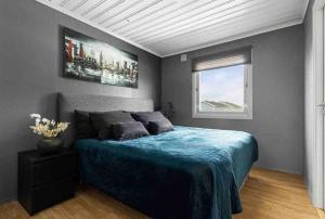 a bedroom with a blue bed and a window at House in Skien/Porsgrunn in Skien