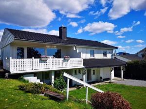 a white house with a porch and a balcony at House in Skien/Porsgrunn in Skien