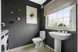 a bathroom with a sink and a toilet and a window at House in Skien/Porsgrunn in Skien