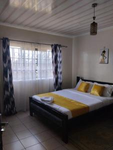 1 dormitorio con 1 cama grande y ventana en Exquisite 2BR Ensuite Apartment close to Rupa Mall, Mediheal Hospital, and St Lukes Hospital, en Eldoret