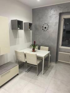 uma sala de jantar com uma mesa branca e cadeiras em San Donato Apartment em Barletta