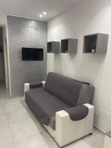 um quarto com um sofá e uma televisão na parede em San Donato Apartment em Barletta