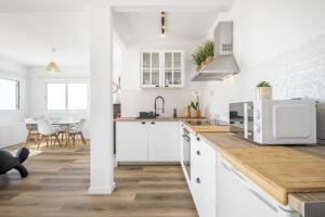 cocina con armarios blancos y encimera de madera en Blue House - By Wehost, en Ponta do Sol