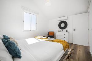 Un dormitorio blanco con una cama blanca y una ventana en Blue House - By Wehost, en Ponta do Sol
