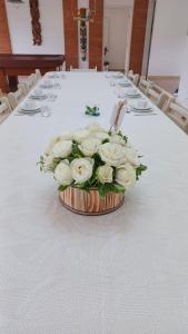 un ramo de rosas blancas sentadas en una mesa en Bela's Suítes- 60 m da praia de Barequeçaba, en Barequeçaba