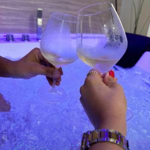 duas pessoas a segurar copos de vinho na neve em Suite Pizzo jacuzzi rooms em Pizzo