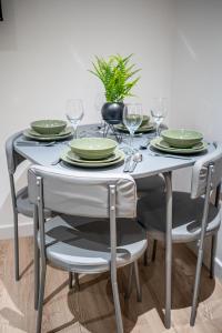 a dining room table with plates and wine glasses at 2-Bedroom Cozy Hideaway Close to Hollingworth Lake in Milnrow in Rochdale