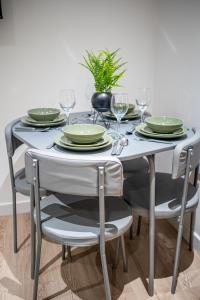 a dining room table with plates and wine glasses at 2-Bedroom Cozy Hideaway Close to Hollingworth Lake in Milnrow in Rochdale +27 photos