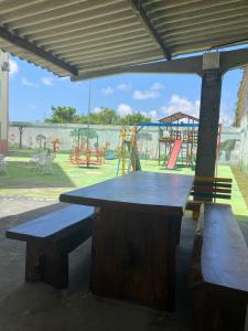 a picnic table and benches in a park with a playground at Lindo apartamento in Aracaju