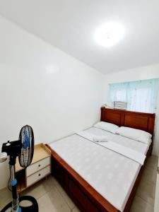 een slaapkamer met een bed, een ventilator en een camera bij Calapan City Guest House Transient in a Subdivision near Malls L41 in Calapan