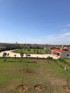 een grasveld met een gebouw en een weg bij Maison Ain Lakssab in Ben Slimane