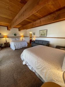 um quarto de hotel com duas camas e um sofá em Berkshire Inn em Groveland