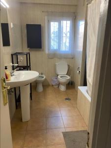a bathroom with a sink and a toilet and a window at Apartamento de habitaciones privadas en el centro de Málaga in Málaga