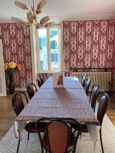 a dining room with a table with a book on it at Grand Gîte à 25 minutes du Puy Du Fou in Montournais