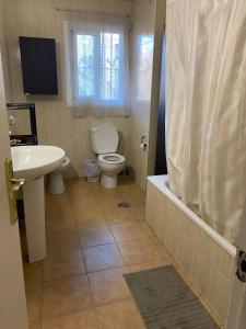 a bathroom with a toilet and a sink and a tub at Apartamento de habitaciones privadas en el centro de Málaga in Málaga