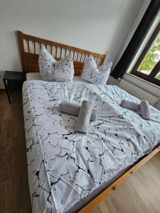 una camera da letto con un grande letto con lenzuola e cuscini bianchi di Großzügige Ferienwohnung mit Balkon a Chemnitz