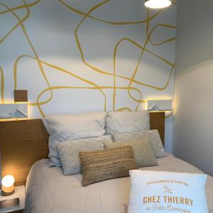 サン・ローラン・デグーズにあるChambres d'hôtes Chez Thierryのベッドルーム1室(大きな壁のベッド1台付)