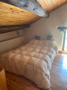 a white bed in a bedroom with a wooden ceiling at chalet st michel de maurienne in Beaune