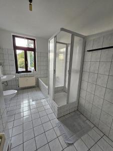 e bagno con doccia, servizi igienici e lavandino. di Großzügige Ferienwohnung mit Balkon a Chemnitz