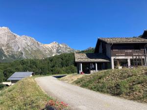 chalet st michel de maurienne في Beaune: منزل على تل بجوار طريق