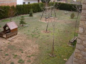 ヘア・デ・アルバラシンにあるApartamentos Artigotの小木とブランコのある庭園