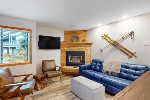 sala de estar con sofá azul y chimenea en Wildflower C-9 101, en Sandpoint