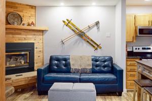 un sofá de cuero azul en una sala de estar con chimenea en Wildflower C-9 101, en Sandpoint