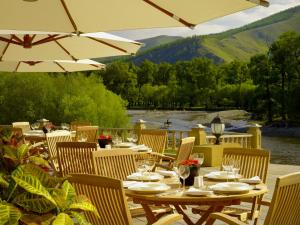 un patio con mesas y sillas y vistas al río en Terelj Hotel & Spa, en Ulán Bator