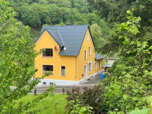 a yellow house with a black roof at Kleine-Radoase in Weilburg