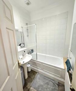 a white bathroom with a tub and a sink at Lovely One Bedroom Appartment in Marylebone Central London - 4 people in London