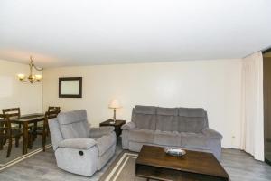 a living room with two chairs and a table at Discovery Bay 2308 condo in Honolulu