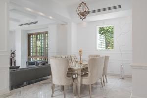 a dining room with a table and chairs at Luxury Allegria Golf Villa with pool in Sheikh Zayed