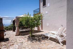 a pair of white chairs sitting next to a building at casa aniello in Caprioli