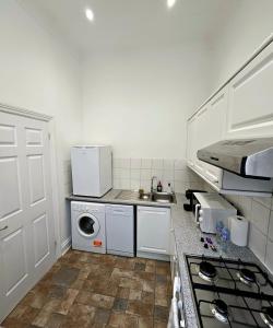 eine kleine Küche mit Spüle und Waschmaschine in der Unterkunft Lovely One Bedroom Appartment in Marylebone Central London - 4 people in London