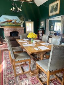 a dining room with a wooden table and a fireplace at The Selsey Arms in West Dean